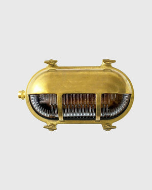 Vintage-style brass light fixture on a grey background