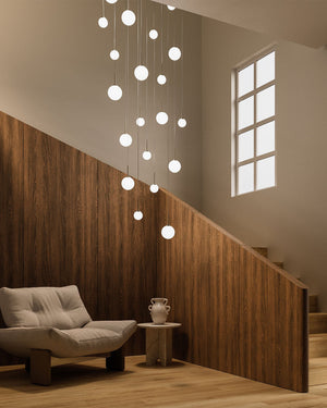 Minimalist Sphere Orb Pendant hanging in a modern interior with a staircase and chair