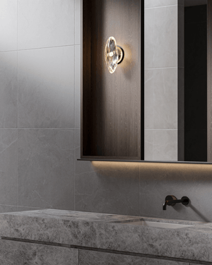 Bathroom interior with a wall-mounted light fixture and marble countertop.