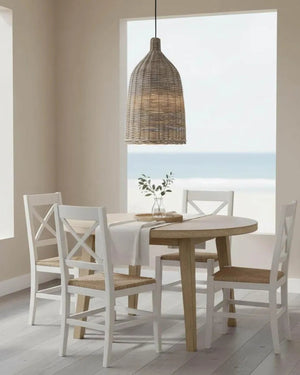 Dining area with wooden table and white chairs, featuring a wicker pendant light.