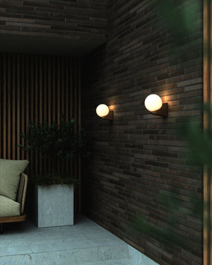 Ribbed Exterior Orb Wall Light Alfresco against a brick wall - Lighting Collective 