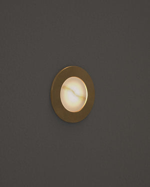 Round gold recessed light fixture on a dark gray background