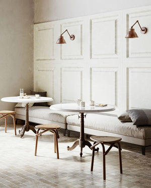 Rustic iron and brass wall lights displayed in a cosy and traditional cafe