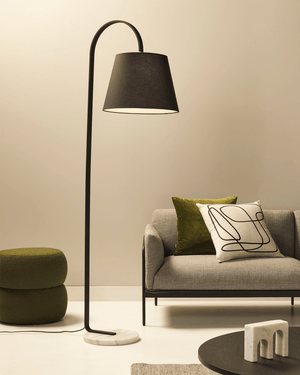Modern living room with a floor lamp, gray sofa, and green ottoman.