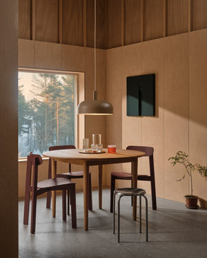 Scandinavian rounded dome pendant light hanging above a minimal and warm dining room interior 