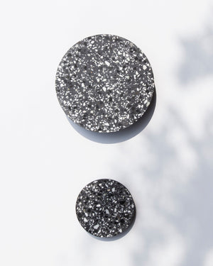 Two round black speckled wall lights on a white background