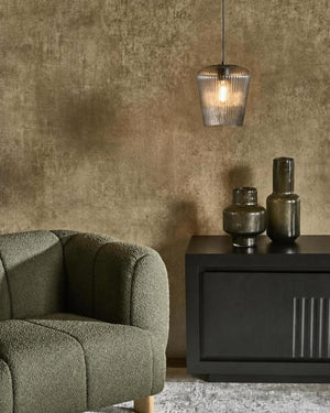 Textured Grey Glass Pendant Light hanging above sideboard in moody living room with olive armchair and textured wall