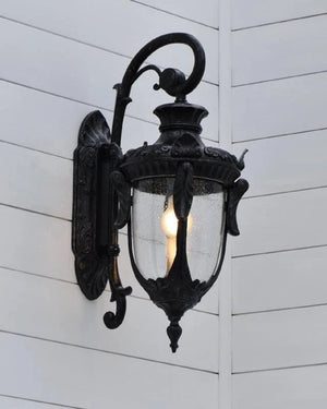Decorative outdoor wall light fixture on a white wooden wall