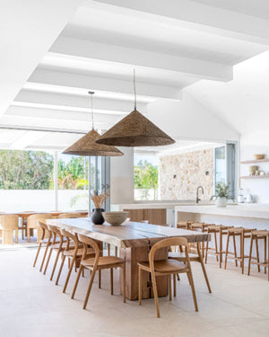 Dark roast conical pendant hanging above coastal style dining table