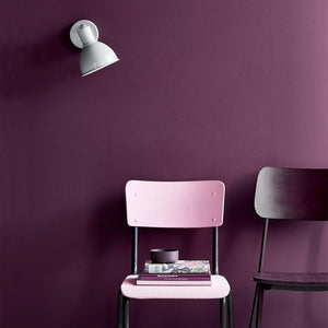 danish adjustable silver detailed wall light white finish next to a pink chair