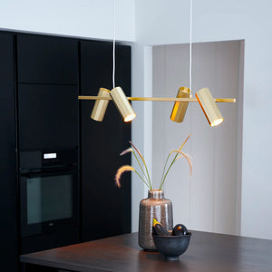 modern metal cylinder shade linear pendant with brass finish over a kitchen island