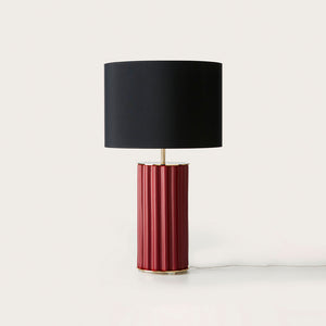 modern ridged ceramic table lamp with matt brass finish, matte maroon base and black fabric shade