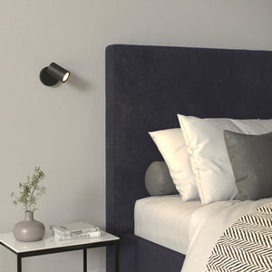modern single switched wall spotlight with black finish on a bedside daylight
