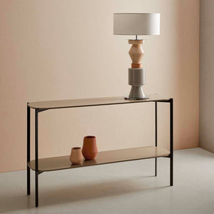 modern tiered glass lamp with a chrome and silhouette and ash grey finish on a table in a living room