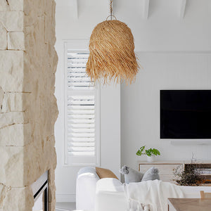 raw edged rattan weave pendant in a living room suspended over a sofa