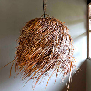 raw edged rattan weave pendant with raw edges beside a window