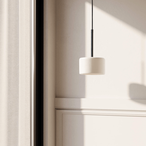 Compact Cylindrical Ceramic Pendant Light black and white finish in a living room close to a window